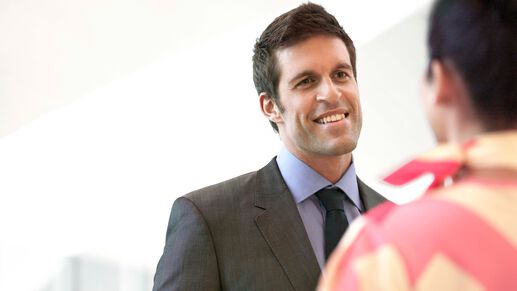 male client in a suit smiling at a female marhaba representative